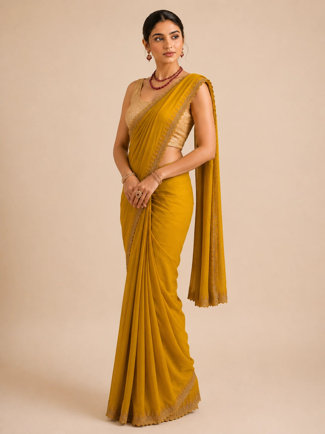 Woman in elegant mustard  saree with delicate embroidered border and golden blouse.