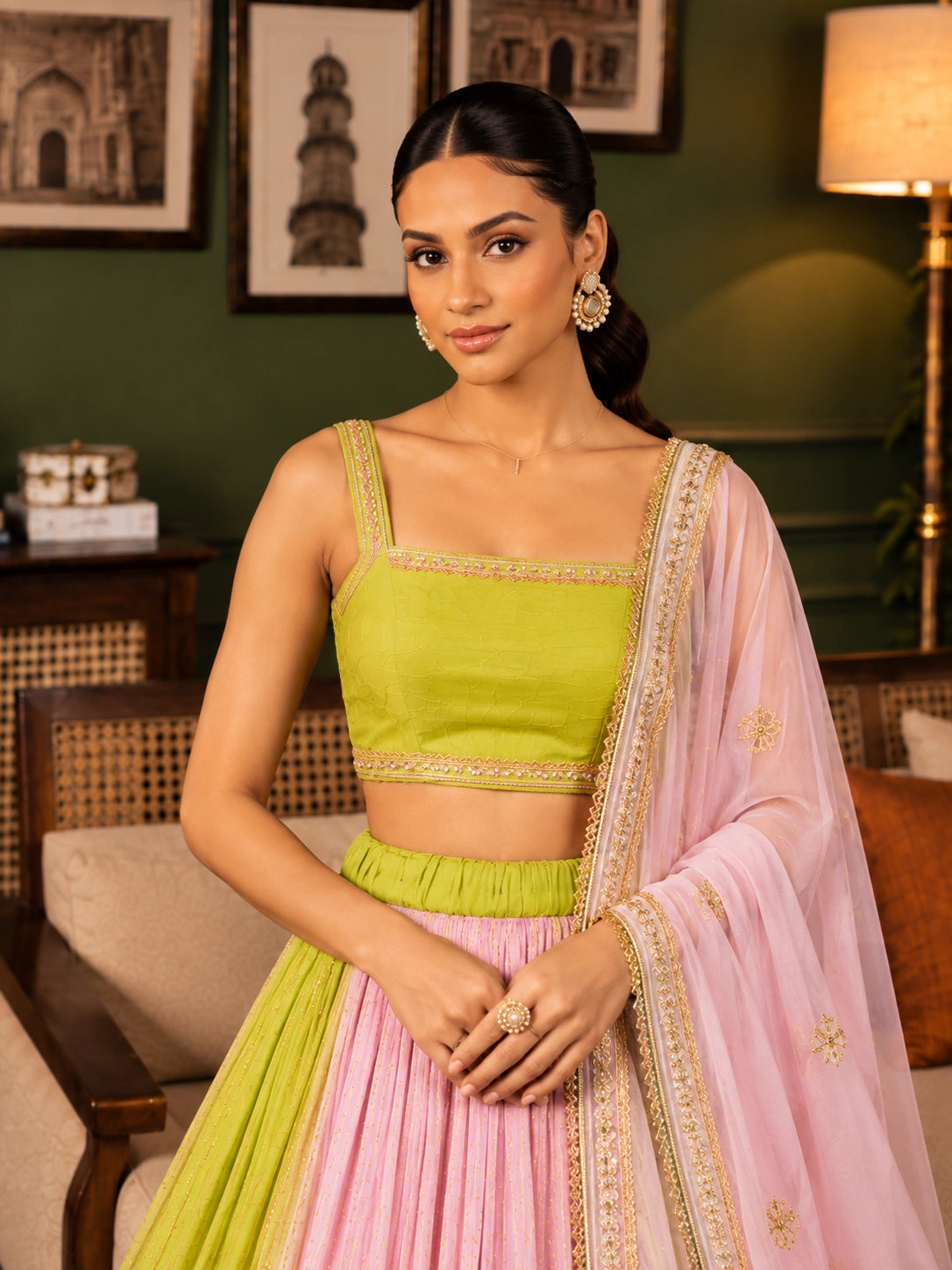 Elegant woman wearing a pink and green  lehenga choli with gold embroidery.