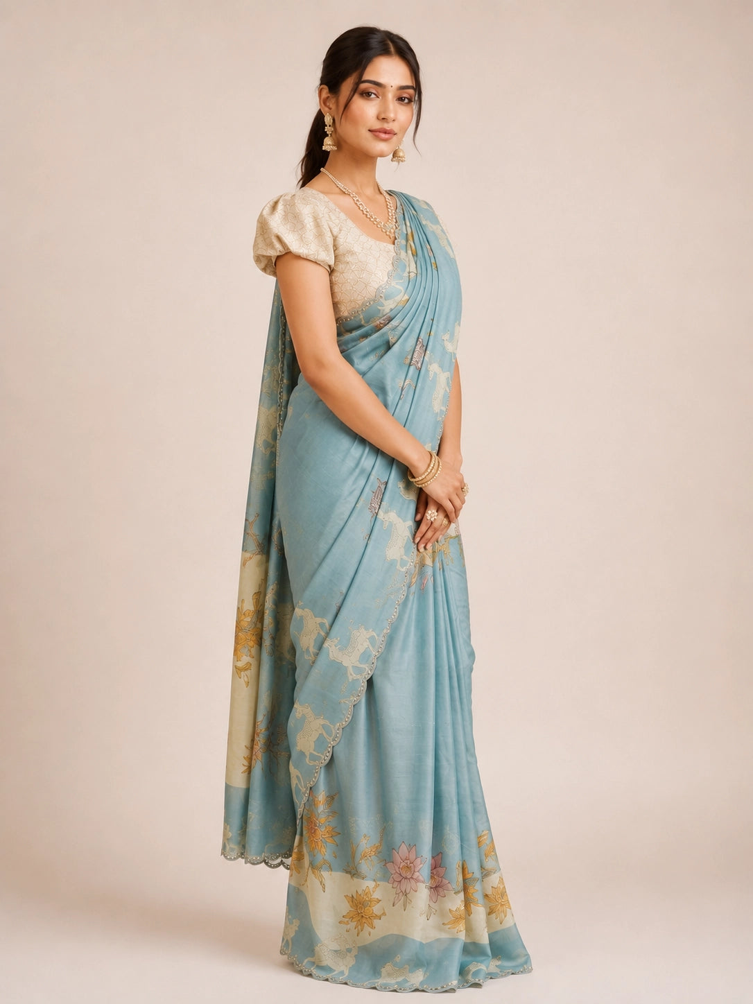 Woman in an elegant sky blue  floral saree with a cream textured blouse.