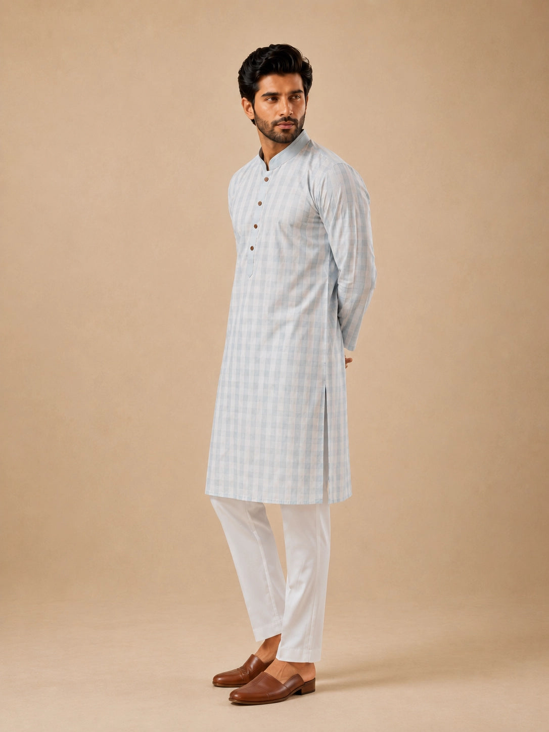 Man wearing a light sky blue and white checkered kurta with white pajamas.