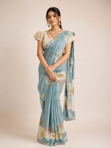 Woman in an elegant sky blue  floral saree with a cream textured blouse.
