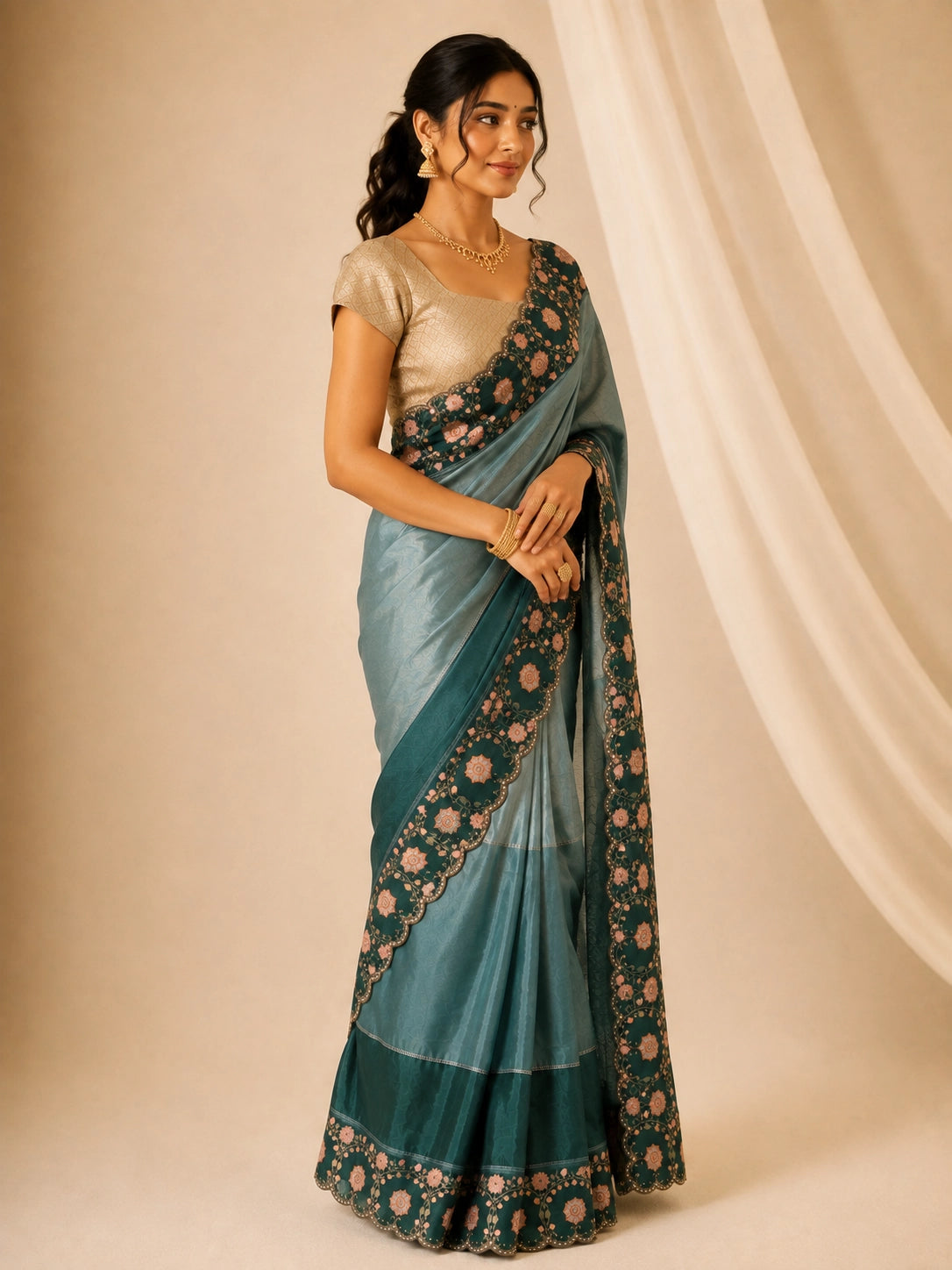 Woman wearing an elegant green embroidered saree with a golden blouse and traditional jewelry.