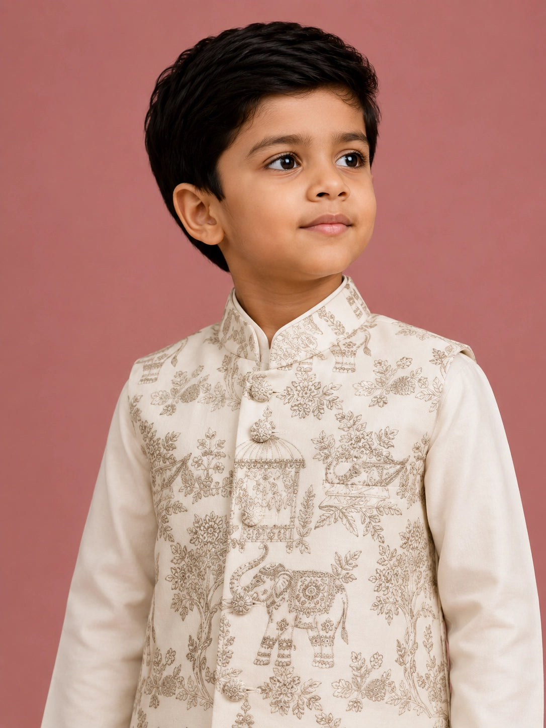 Young boy wearing an off-white embroidered bandhgala waistcoat over a kurta pajama.