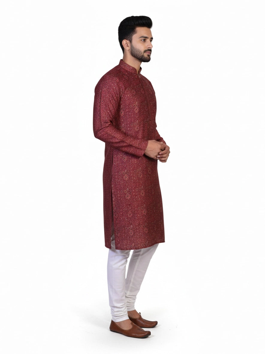 Man wearing a maroon printed kurta with white pants and brown shoes, showcasing traditional Indian attire.