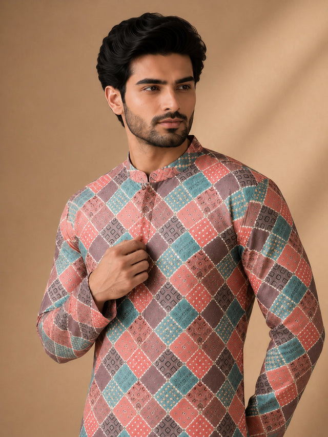Man in a vibrant geometric diamond print kurta, white pajama, and brown loafers.