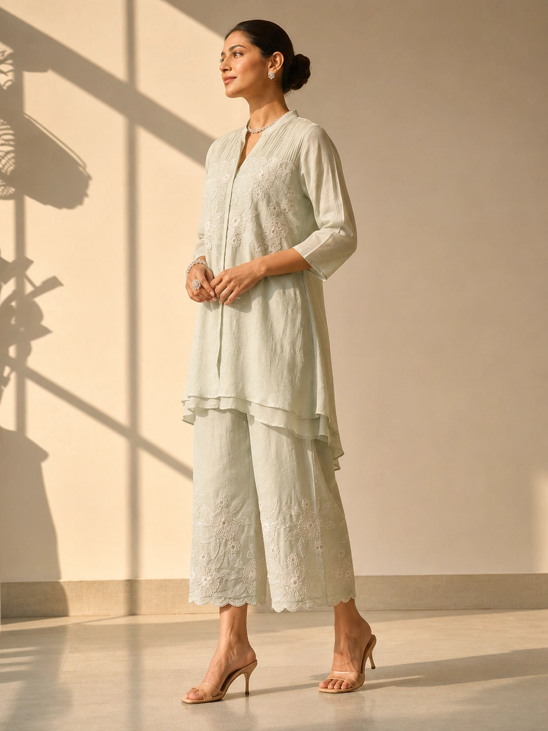 Woman in an elegant pista green embroidered tunic and wide-leg palazzo set.