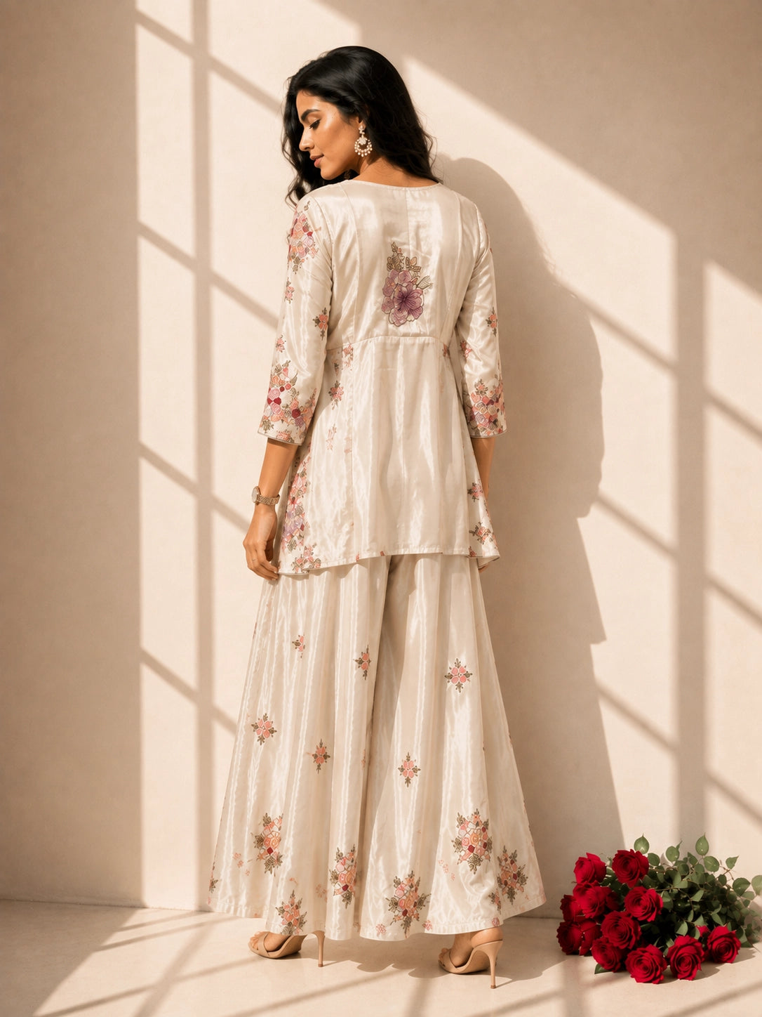 Woman in elegant cream floral embroidered kurti set with sharara and dupatta.