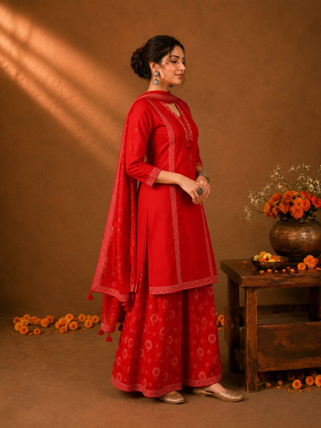 Woman in a Rani red printed Kurti Set with a dupatta, showcasing intricate patterns and elegant drape.