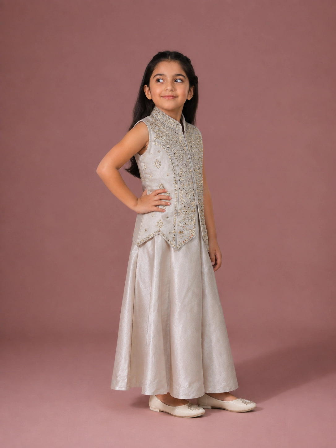 A young girl in a cream embroidered sleeveless top and matching wide-leg palazzo pants.