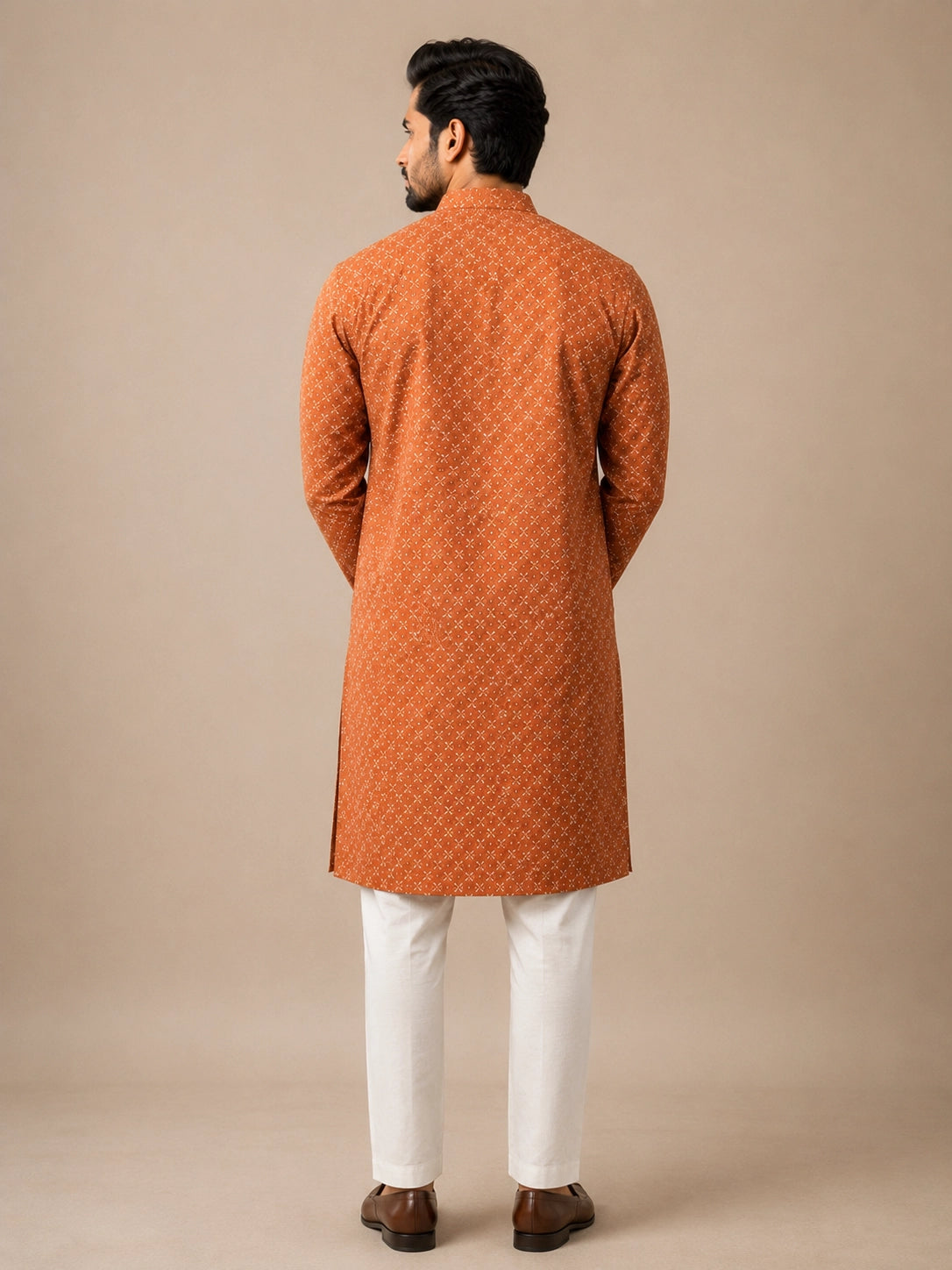 Man wearing a brown printed kurta with a band collar and white pajama.