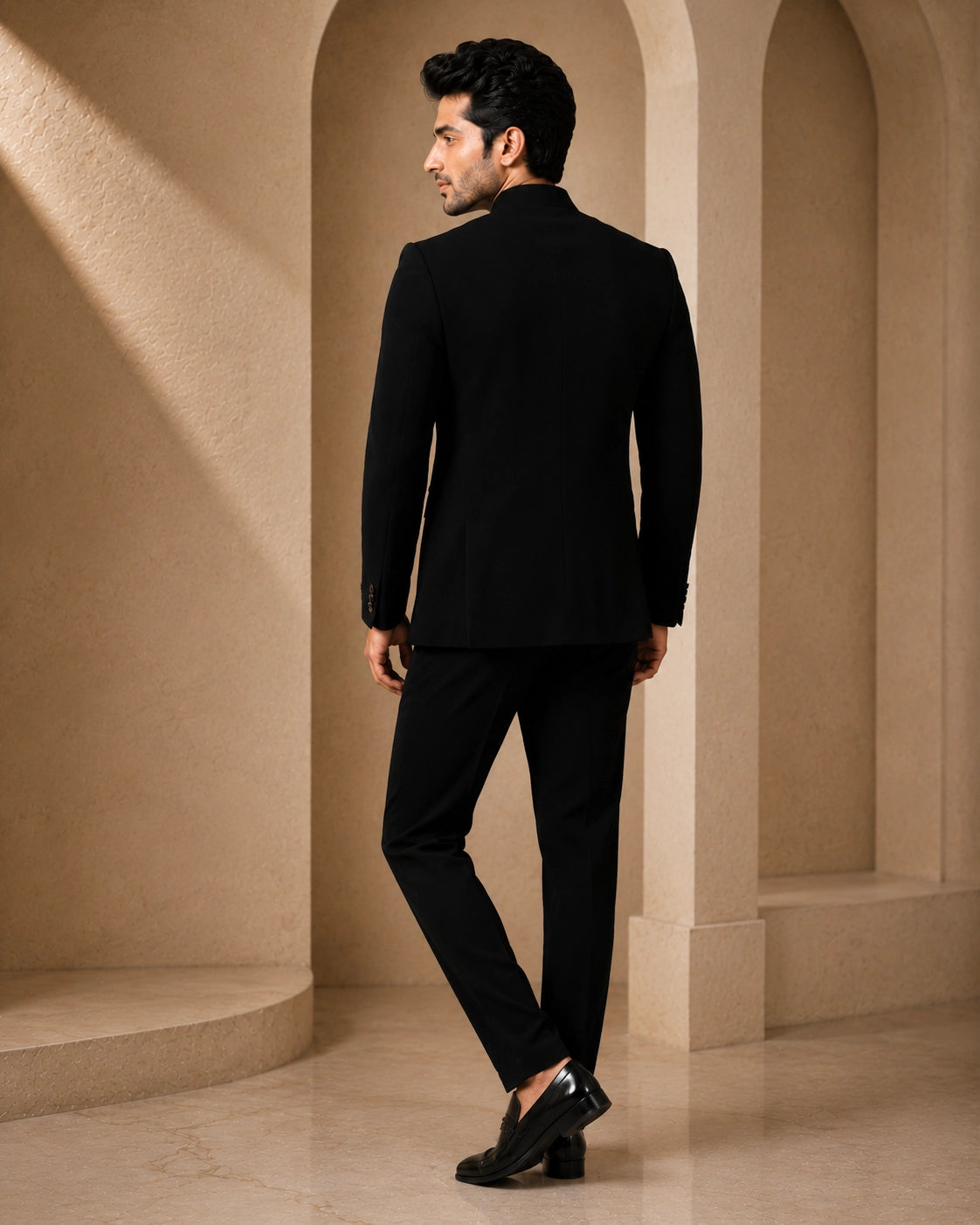Man wearing a classic black Jodhpuri suit, a traditional Indian formal outfit.