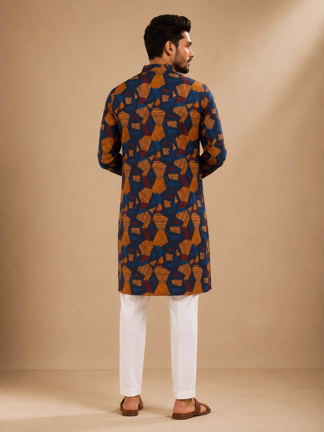 Men's navy kurta with geometric print, paired with white pajama bottoms and brown sandals.