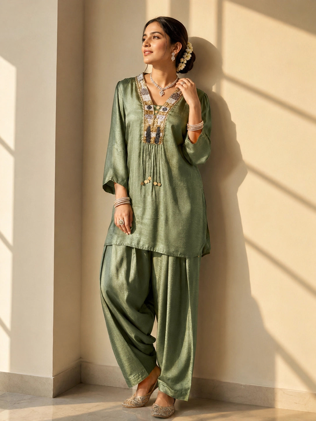 Woman wearing an elegant green textured kurti set with intricate embroidered neckline.