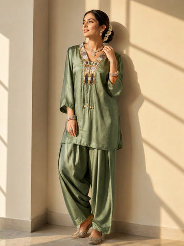 Woman wearing an elegant green textured kurti set with intricate embroidered neckline.