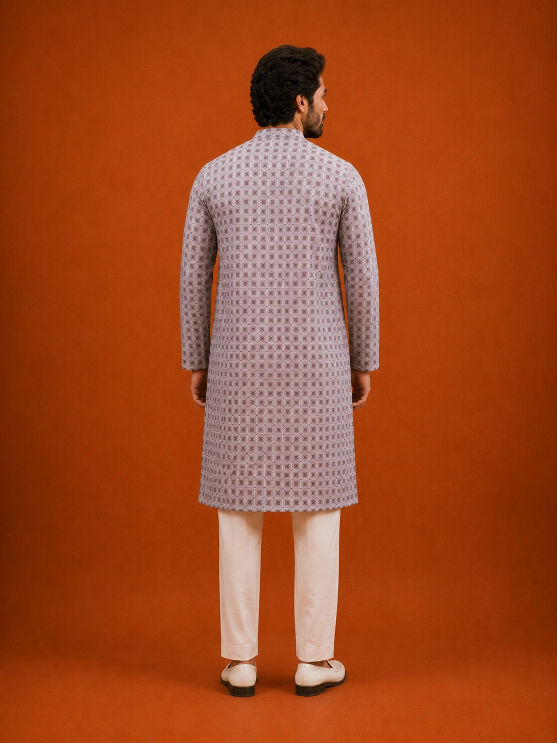 Man wearing a slaty patterned kurta with a mandarin collar, paired with cream pajama.
