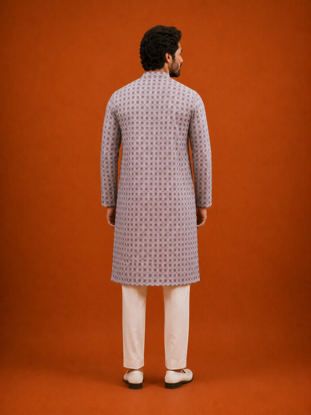 Man wearing a slaty patterned kurta with a mandarin collar, paired with cream pajama.