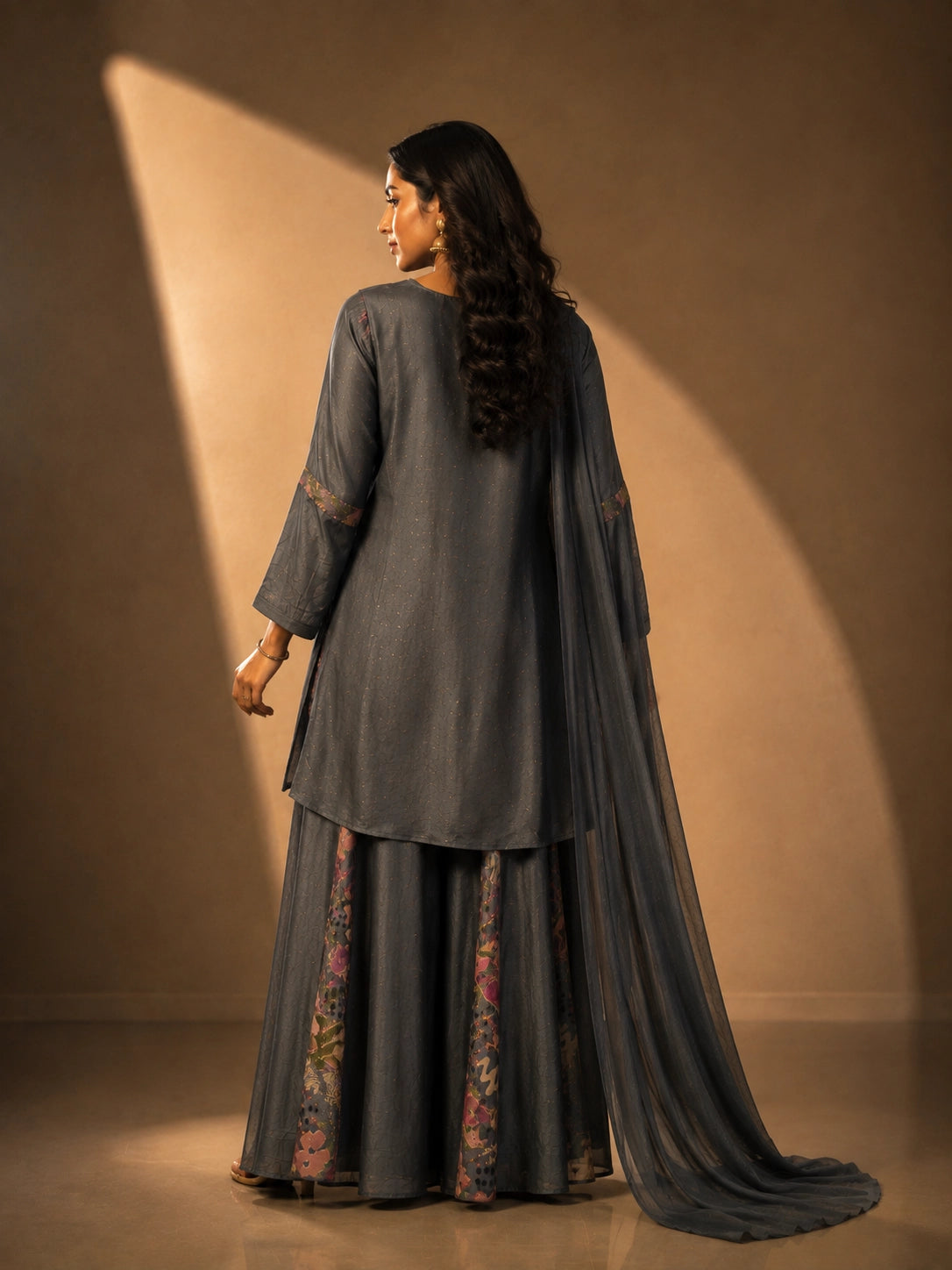 Woman wearing an elegant grey embroidered kurti set with sharara pants and dupatta.