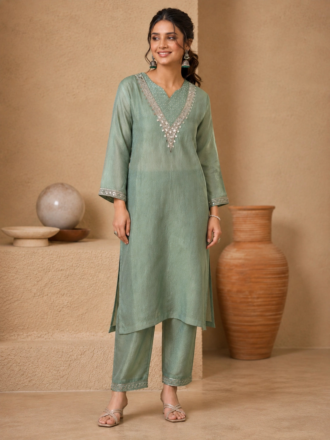 Woman wearing a green embroidered Sharara with silver embellishments on the neckline and cuffs.