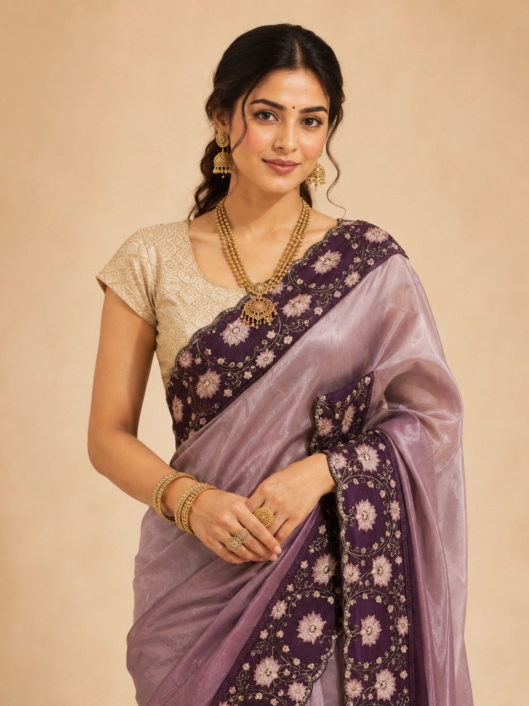 Woman in an elegant wine  saree with intricate floral embroidery and a golden blouse.