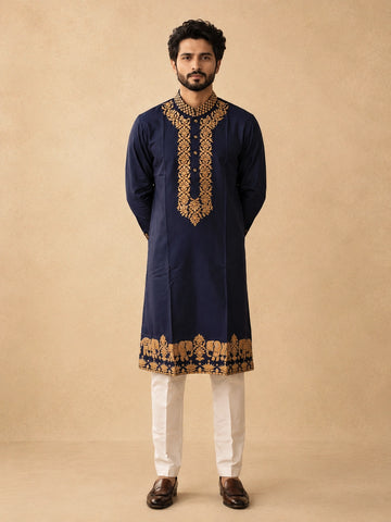 Man wearing a navy blue kurta pajama with intricate gold embroidery and elephant motifs.