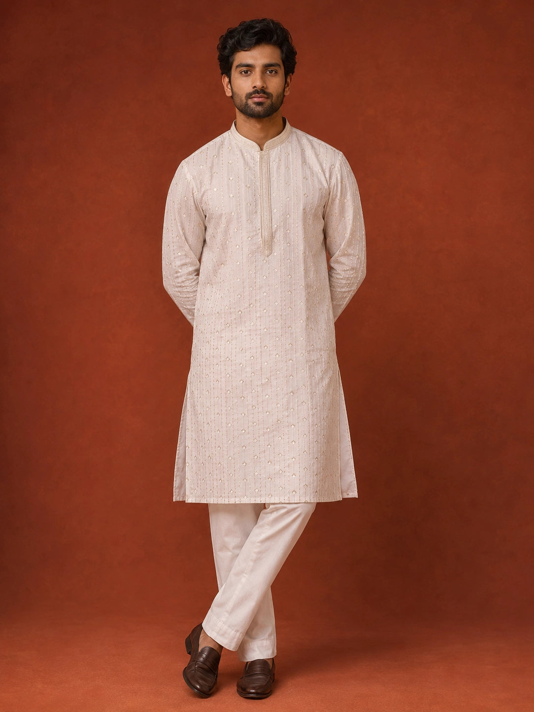Man in elegant white kurta pajama with subtle vertical and diamond patterns.