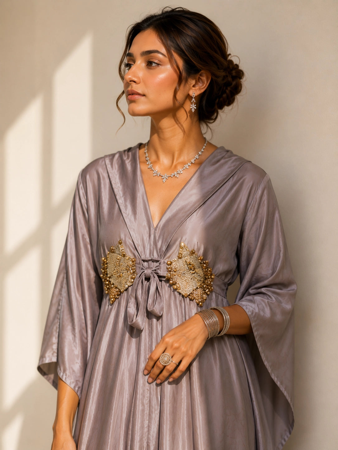 Woman in an elegant onion-colored layered kurti with golden waist detail and matching palazzo pants.