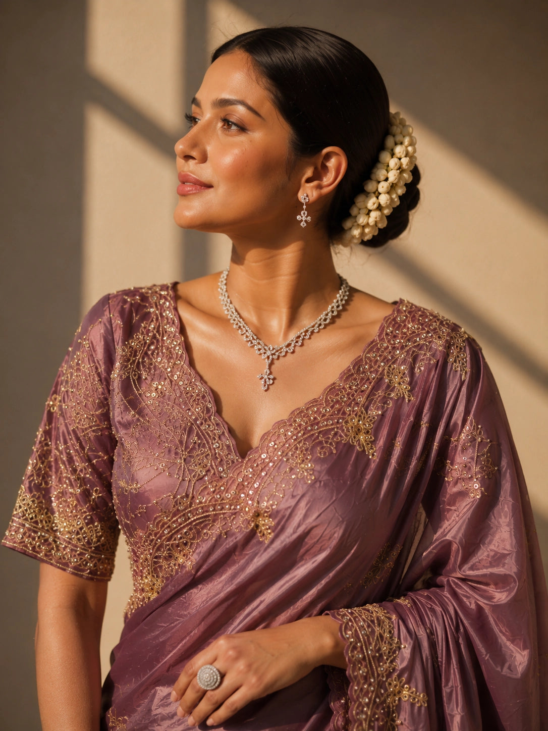 Woman in an elegant onion silk saree with intricate gold embroidery.