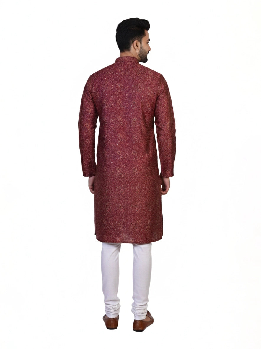 Man wearing a maroon printed kurta with white pants and brown shoes, showcasing traditional Indian attire.
