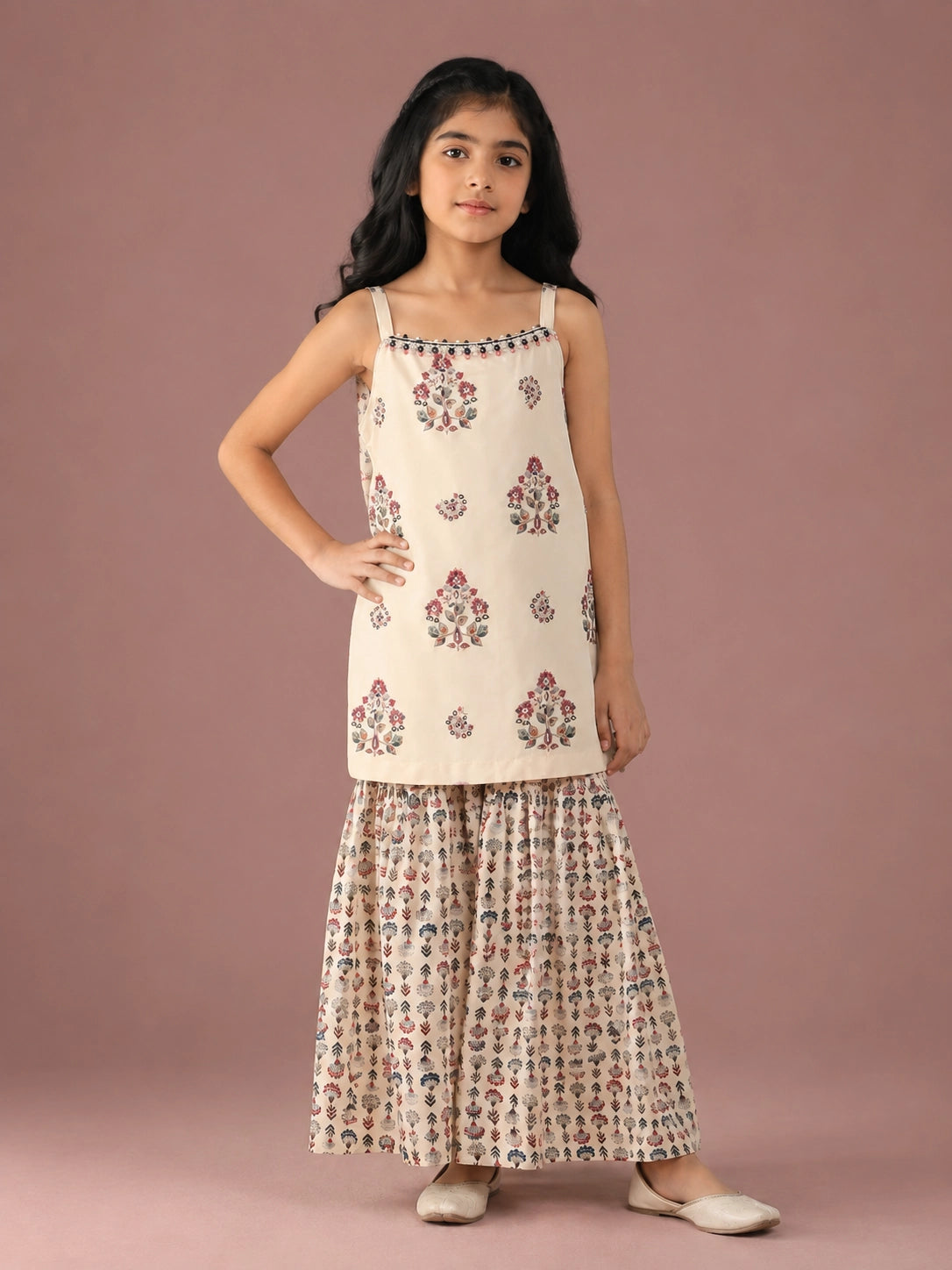 Young girl in a cream floral print strappy top and matching flared sharara set.