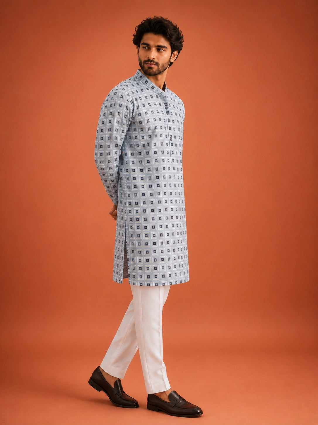 Man wearing sky blue geometric print kurta with white pajama and dark loafers.