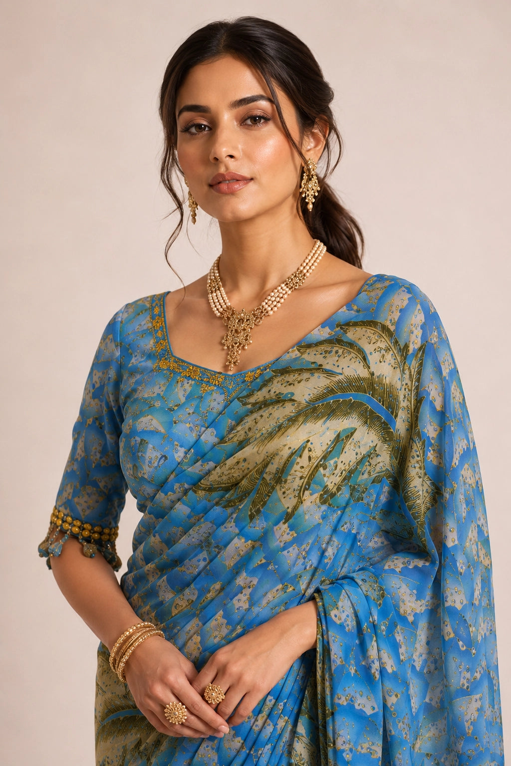 Woman wearing a sky blue  printed saree with olive feather patterns.