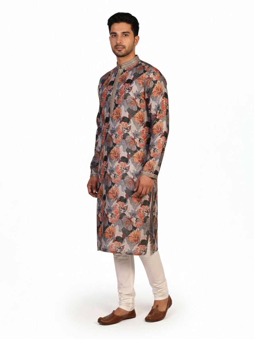 Man wearing a multi-color floral print kurta with an embellished neckline and cream churidar pants.