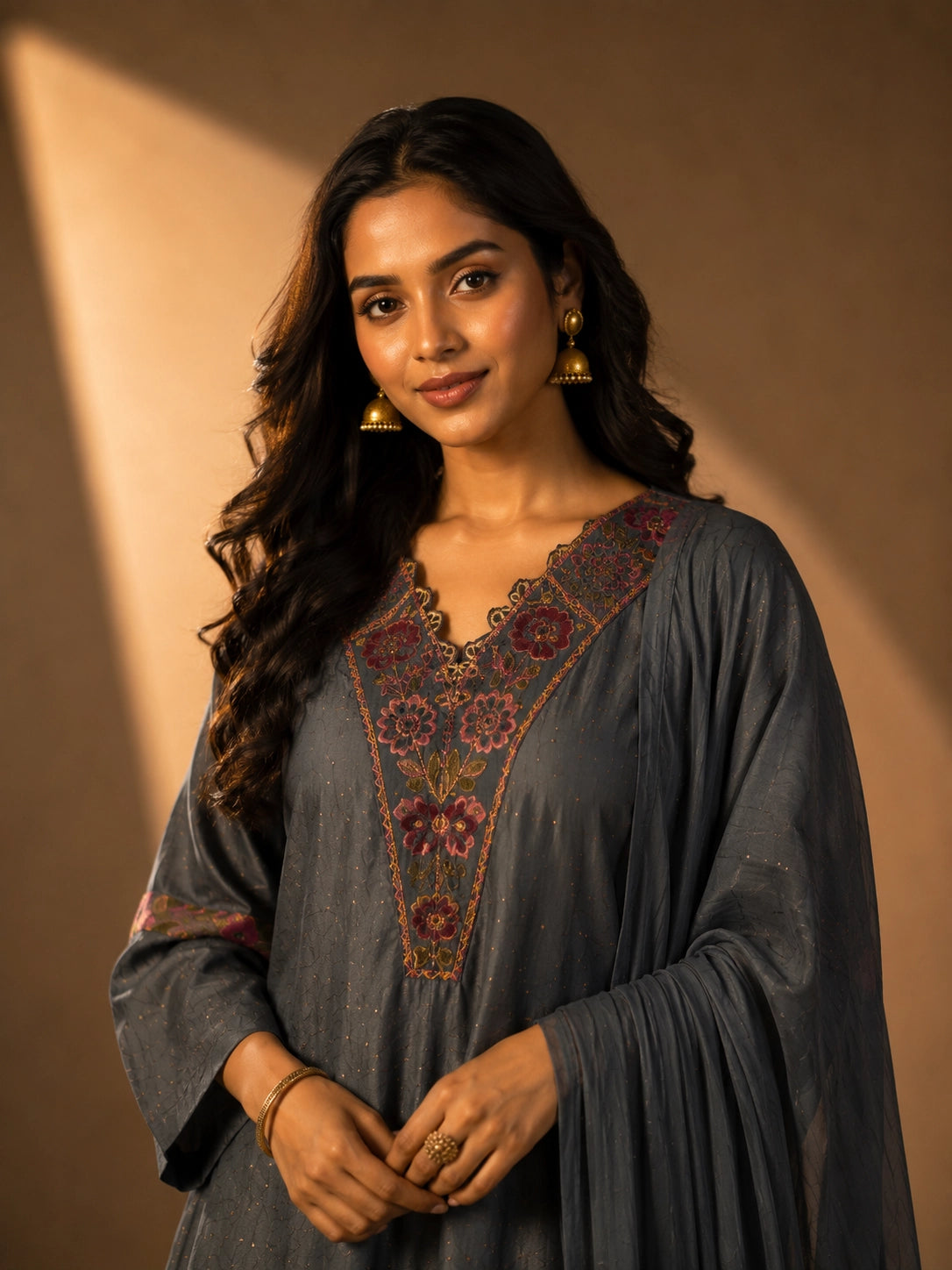 Woman wearing an elegant grey embroidered kurti set with sharara pants and dupatta.