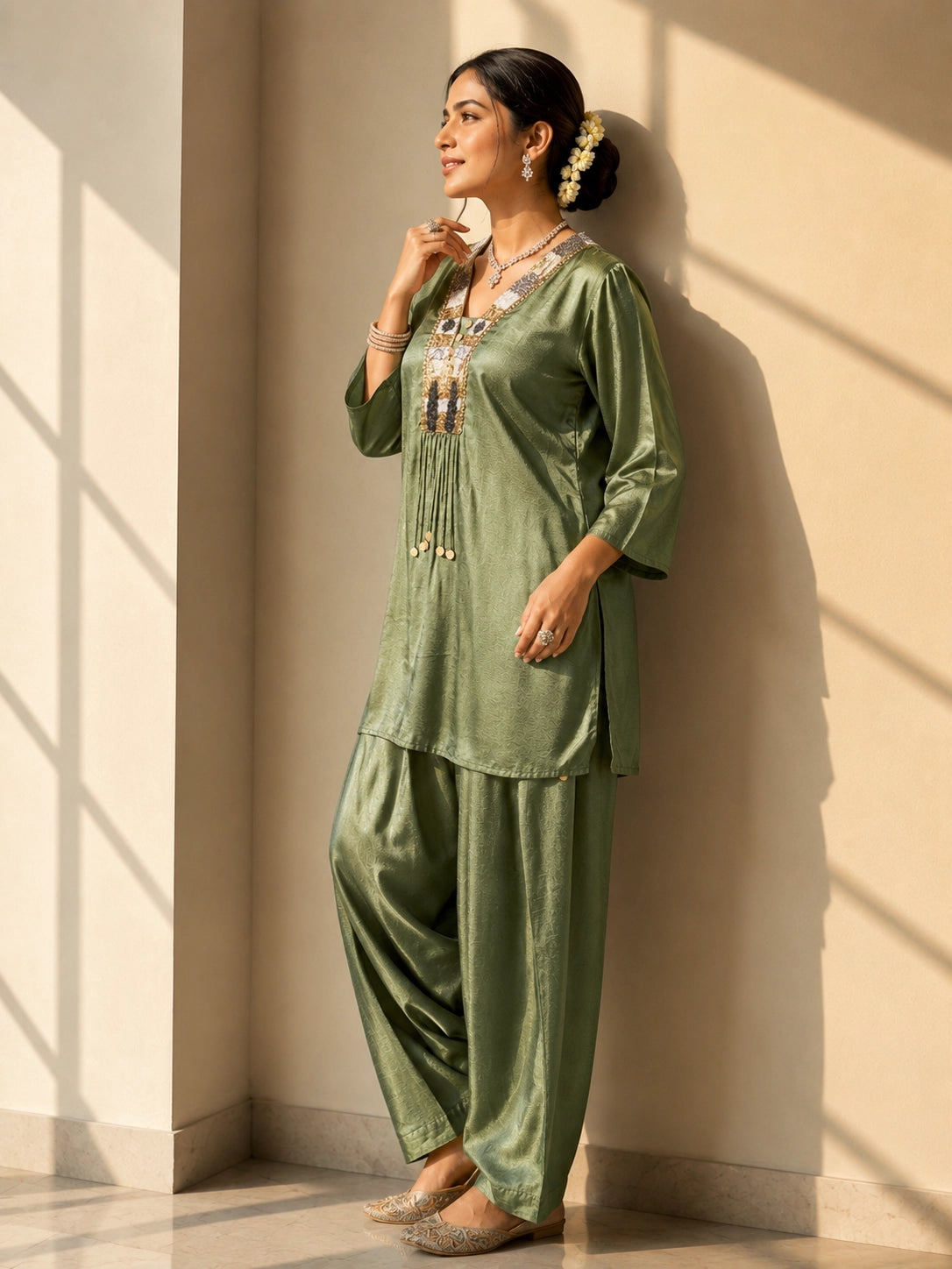 Woman wearing an elegant green textured kurti set with intricate embroidered neckline.