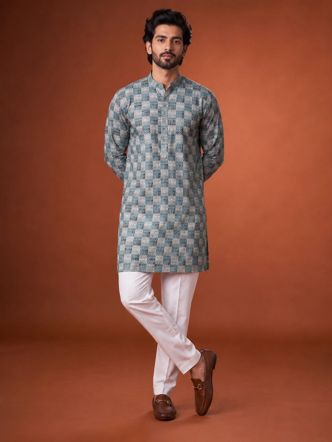 Man wearing a green and grey checkered kurta with white pajama and brown loafers.