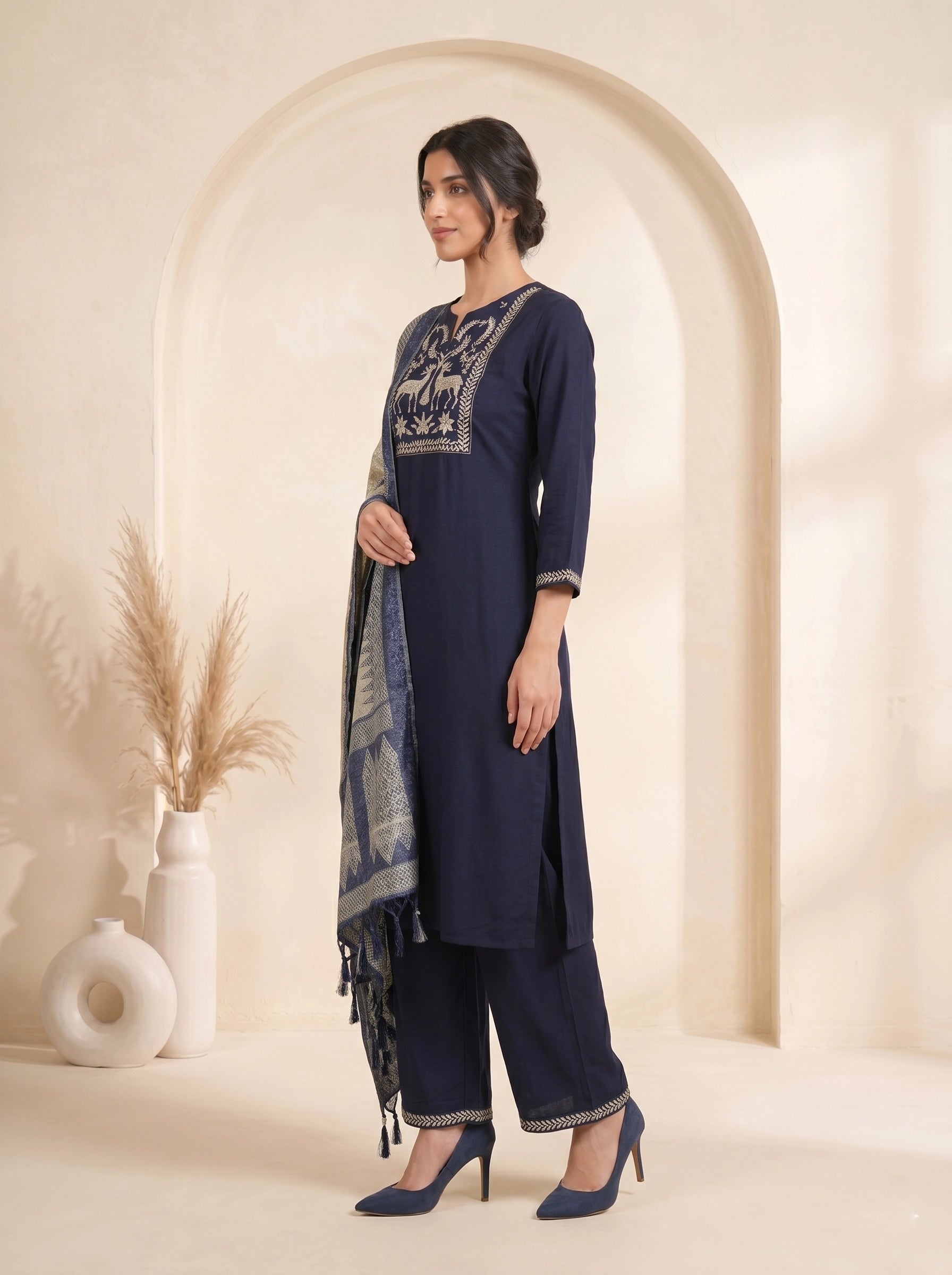 Navy blue embroidered kurti and pants set with a printed dupatta draped over the shoulder.