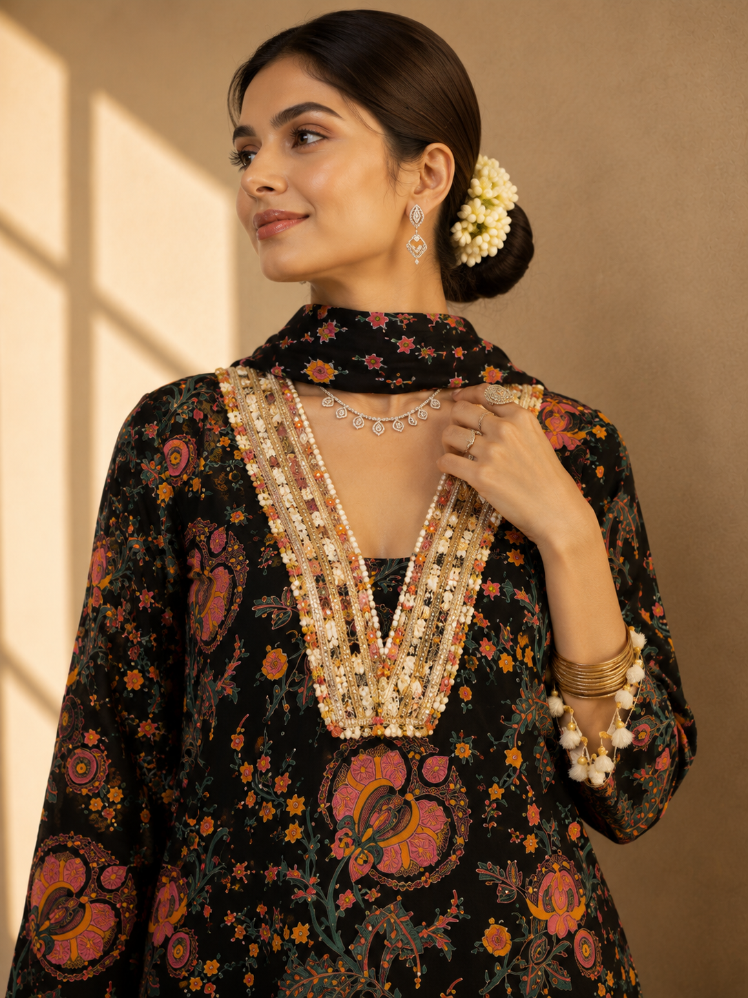 Woman in a black floral kurti set with embroidered V-neck and matching palazzo pants.