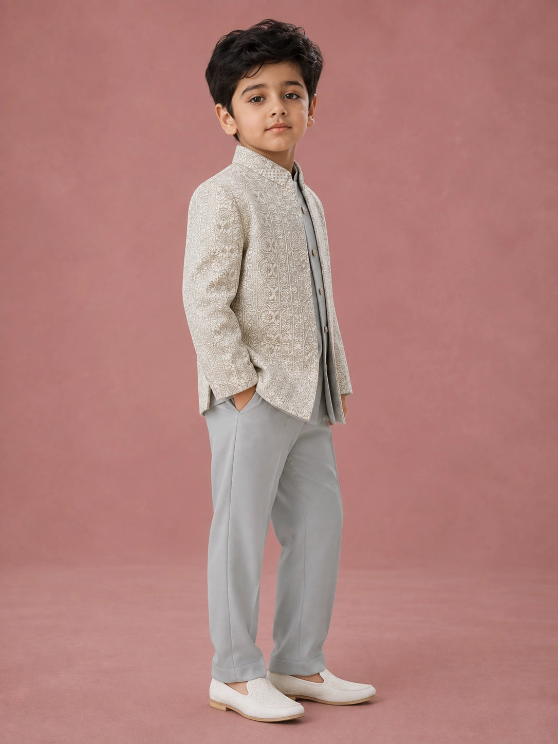 Young boy wearing a pista green Indo-Western suit with an intricately embroidered jacket.