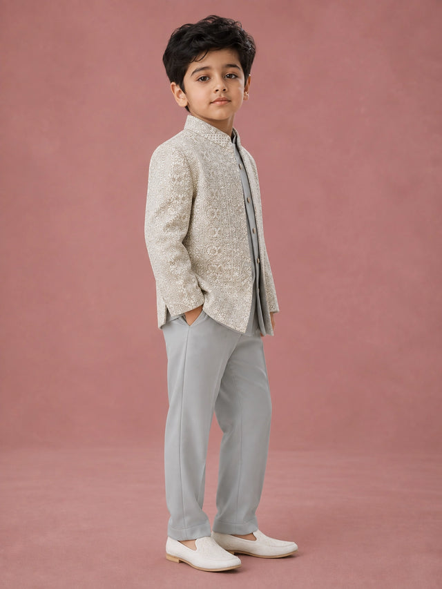 Young boy wearing a pista green Indo-Western suit with an intricately embroidered jacket.