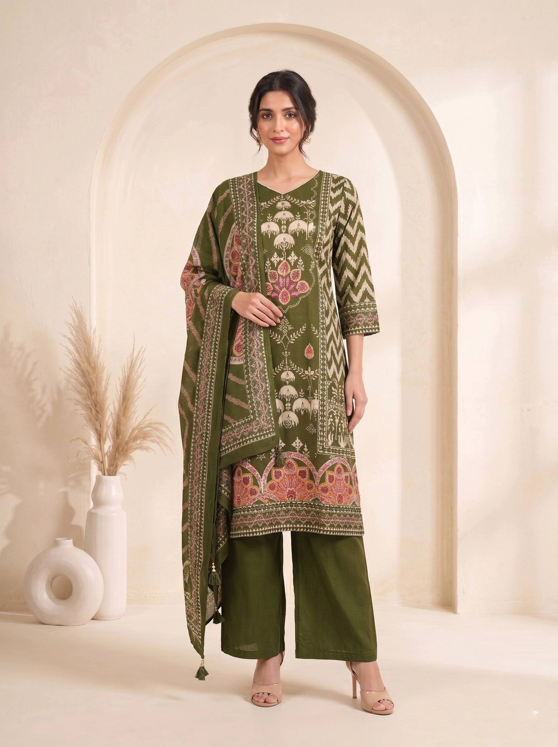 Woman wearing an olive green printed kurti set with palazzo pants and a matching dupatta.