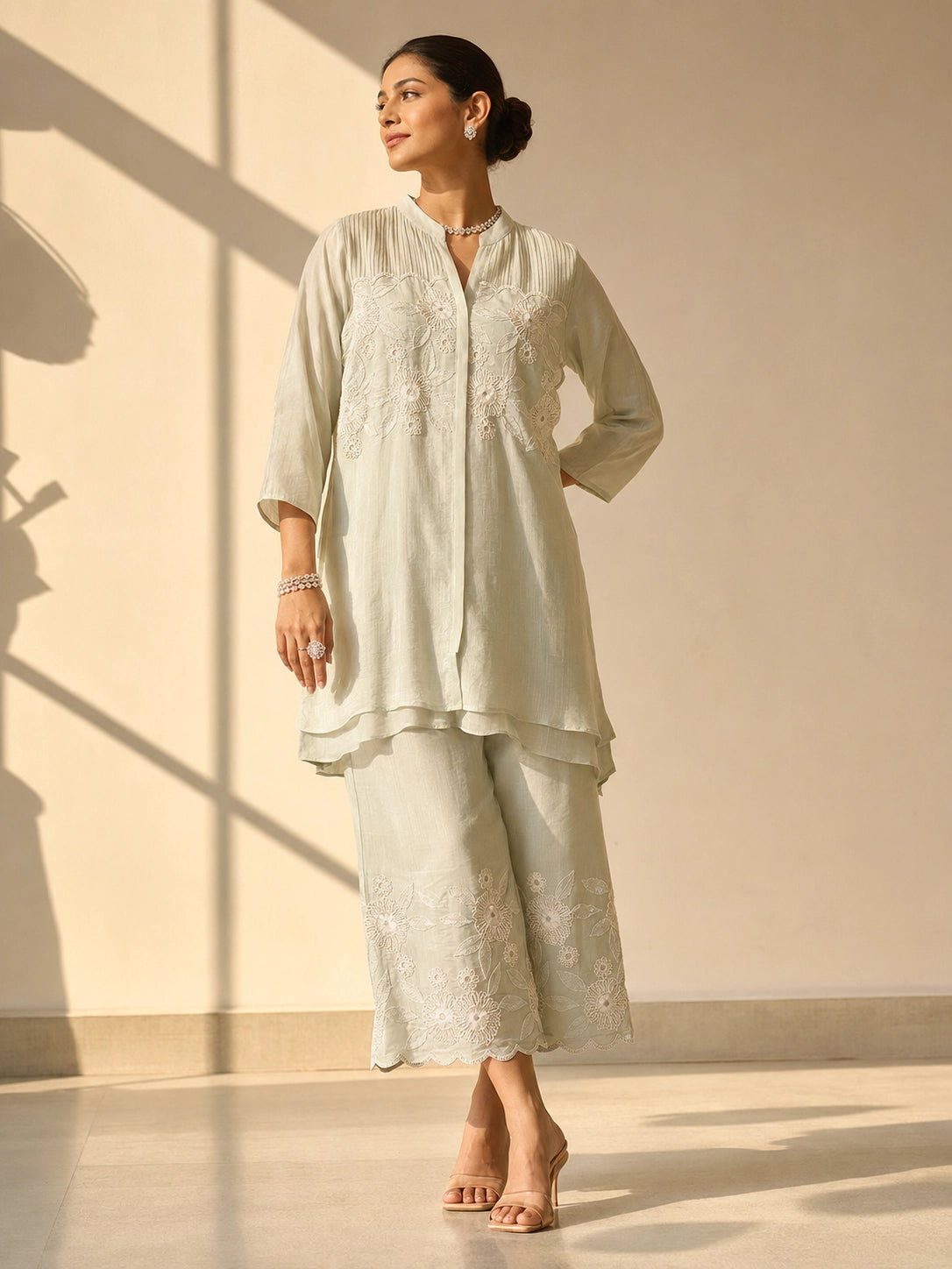 Woman in an elegant pista green embroidered tunic and wide-leg palazzo set.