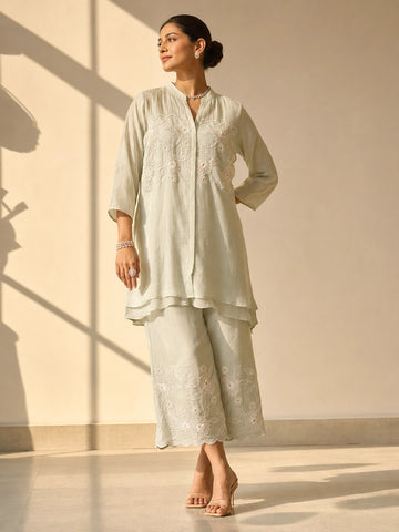 Woman in an elegant pista green embroidered tunic and wide-leg palazzo set.