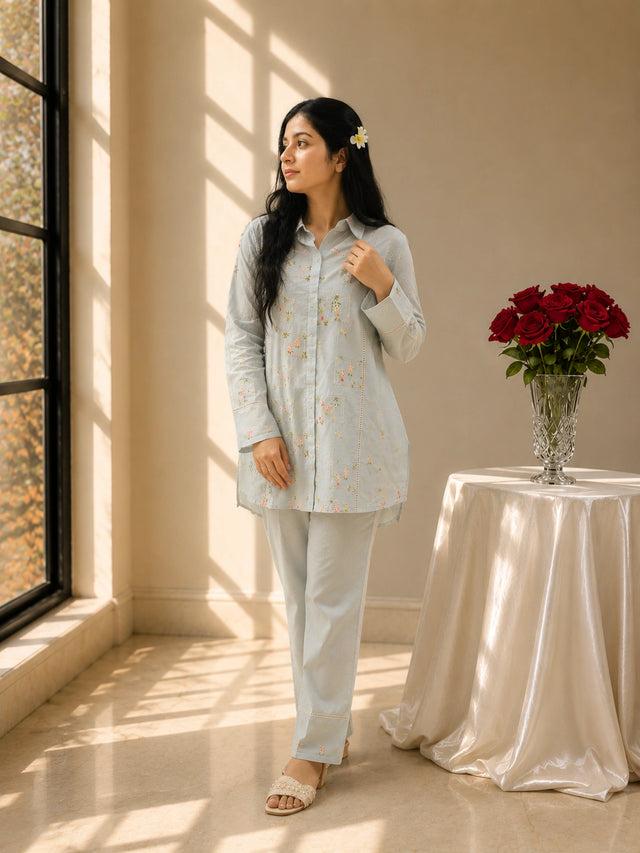 Woman in sky blue floral embroidered kurta set with matching pants.