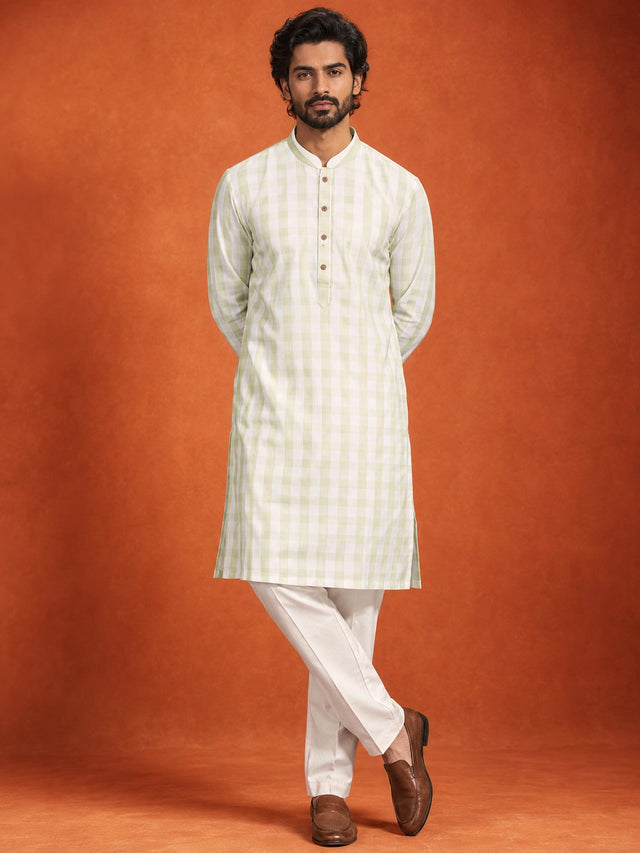 Full-length view of a man in a pista green checkered kurta and white pajama.
