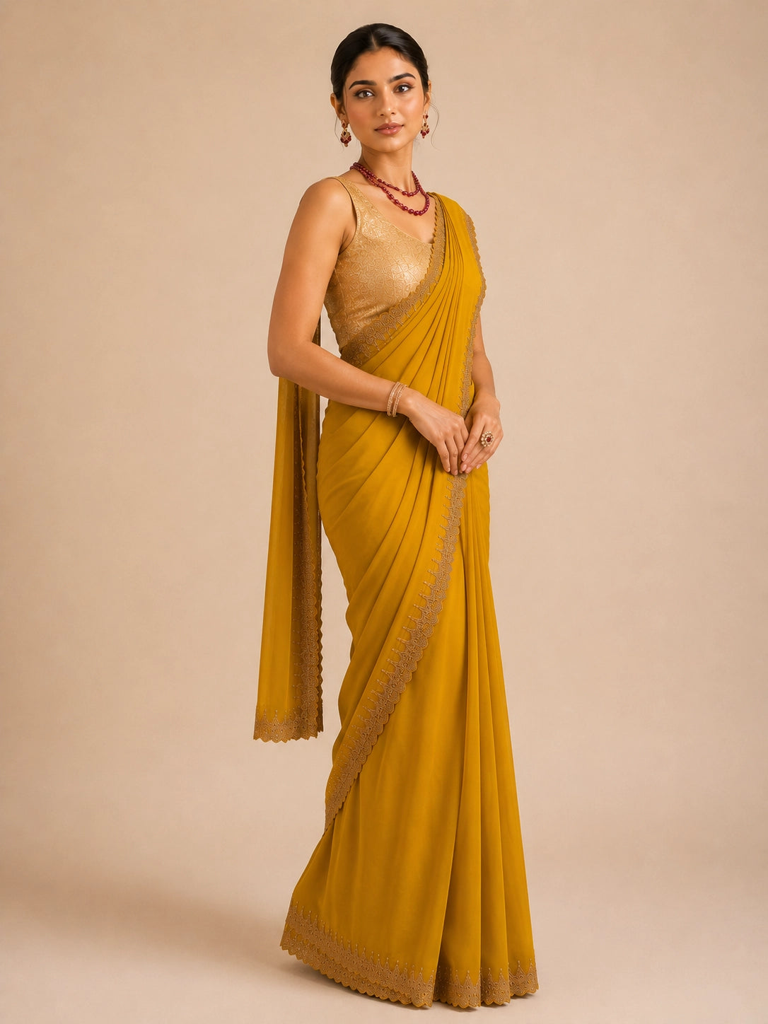 Woman in elegant mustard  saree with delicate embroidered border and golden blouse.