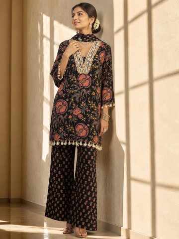 Woman in a black floral kurti set with embroidered V-neck and matching palazzo pants.