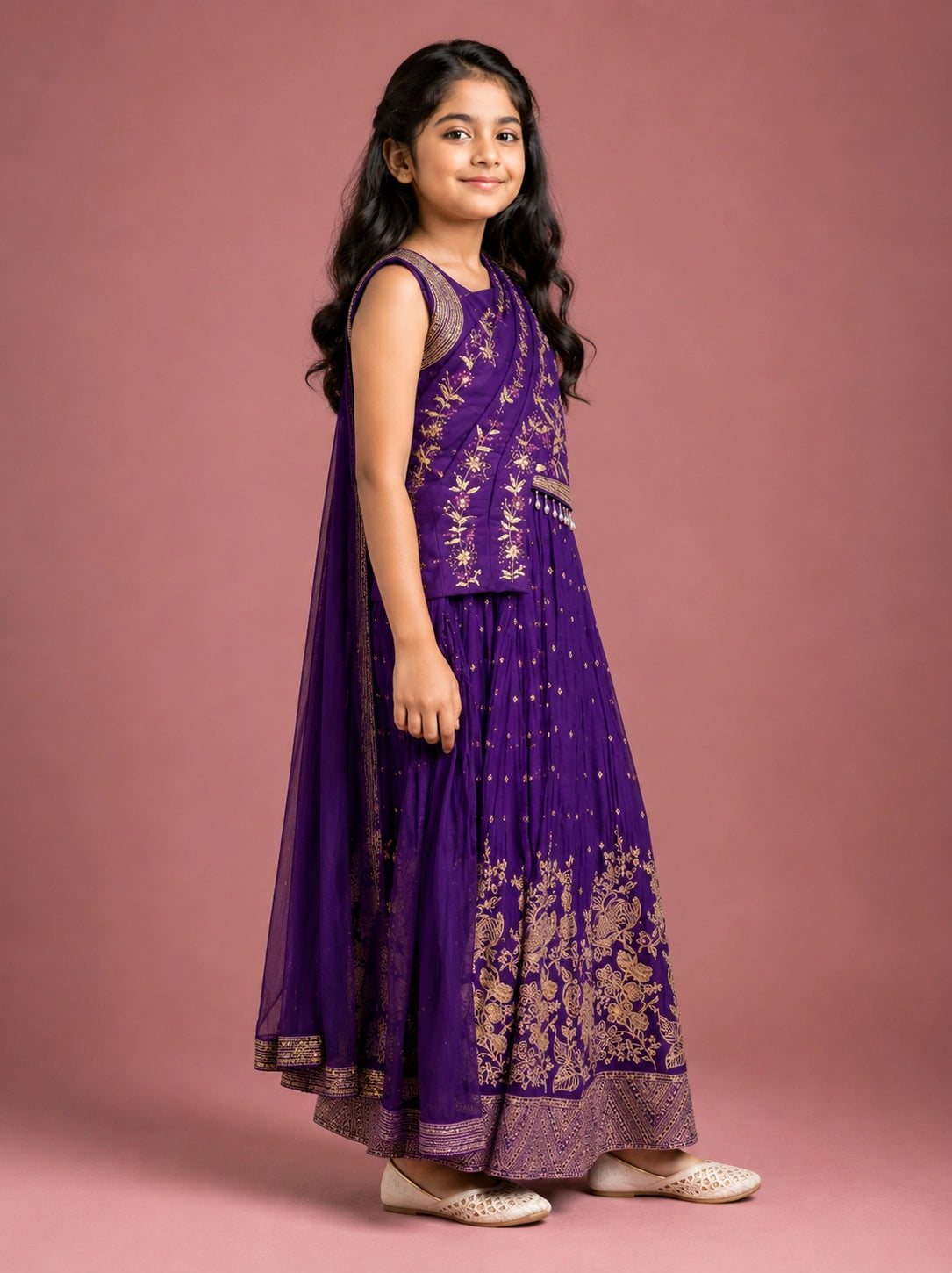 Young girl wearing a vibrant purple lehenga choli with intricate gold embroidery.