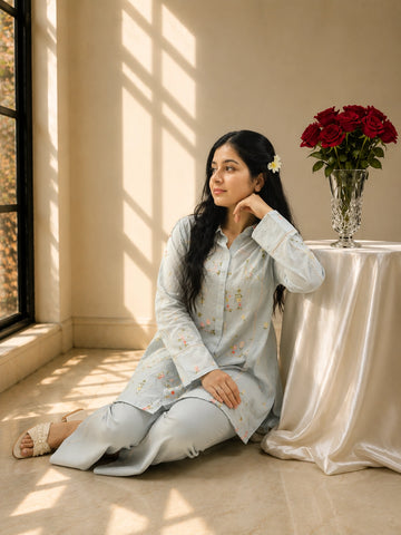 Woman in sky blue floral embroidered kurta set with matching pants.