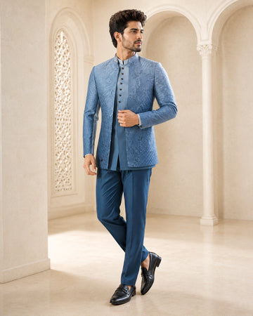 A woman wearing an elegant teal Indowestern outfit, showcasing intricate details and a flattering silhouette.