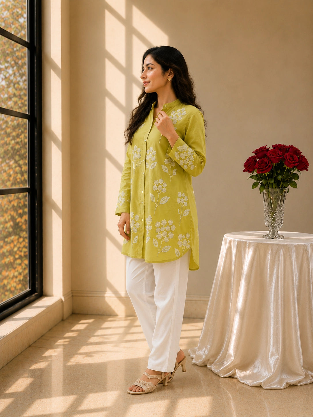 Woman in pista green embroidered tunic kurti and white trousers, smiling.